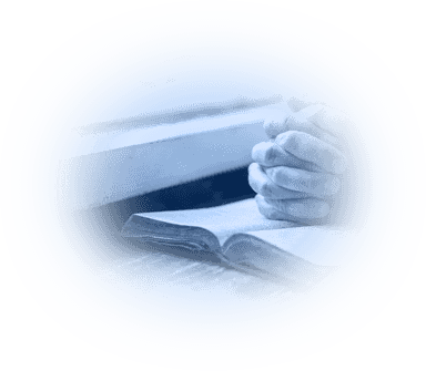 praying hands resting on a Bible